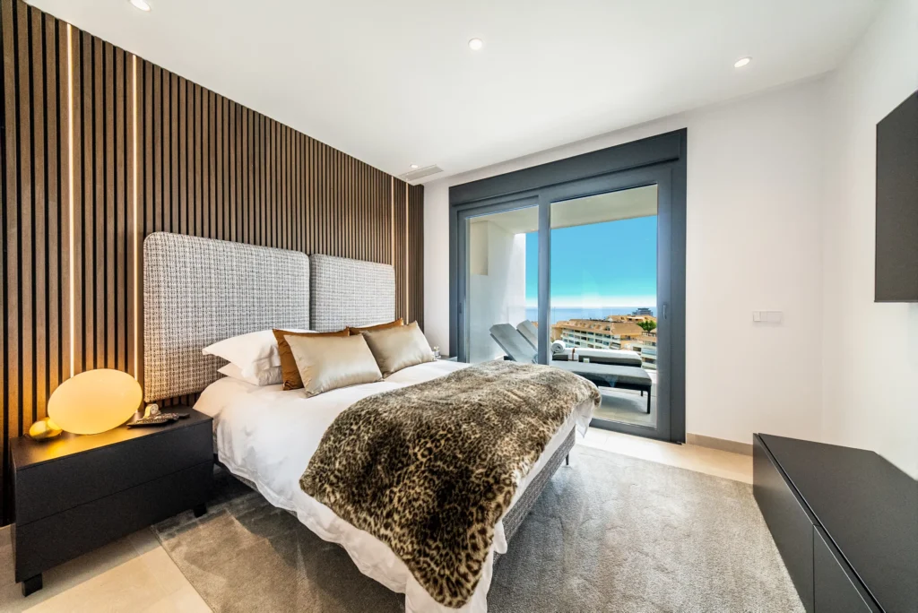 Bedroom with a slatted wood wall and a sea view