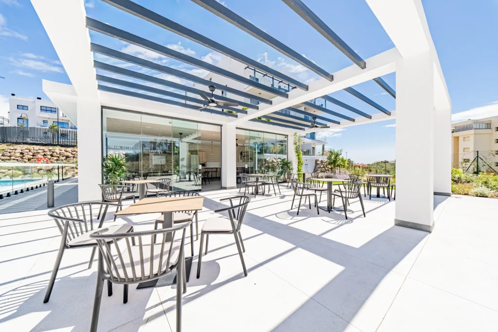 Communal terrace with tables under a modern pergola