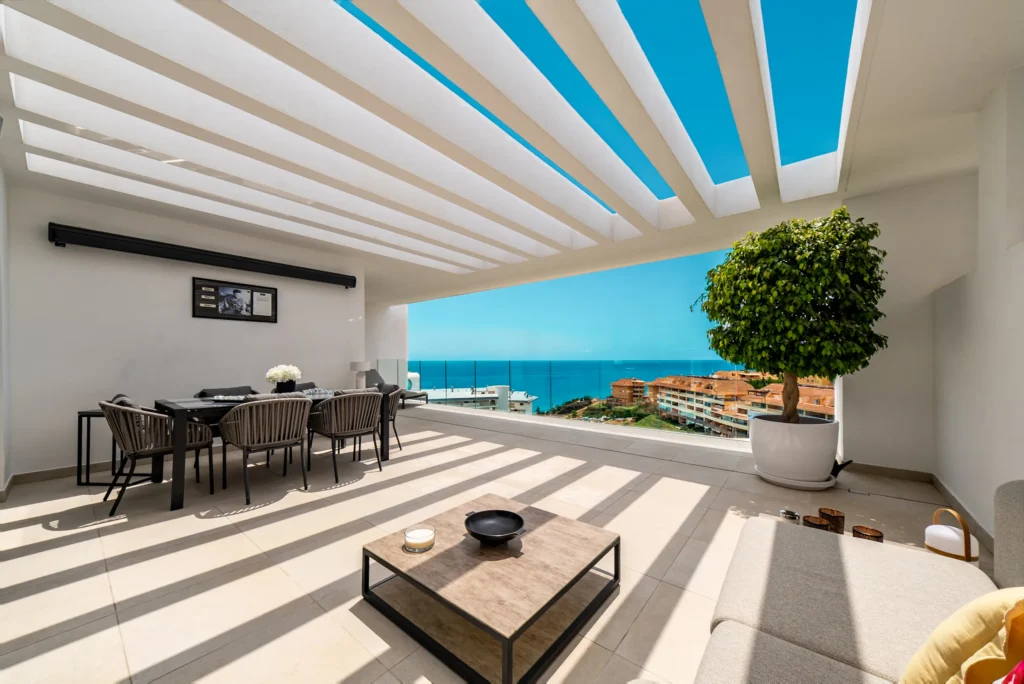 Covered terrace with a dining table and sea views
