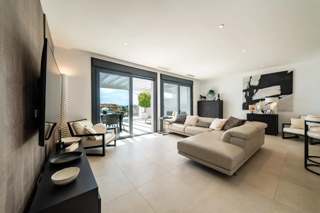 Bright living room with a corner sofa and doors to the terrace