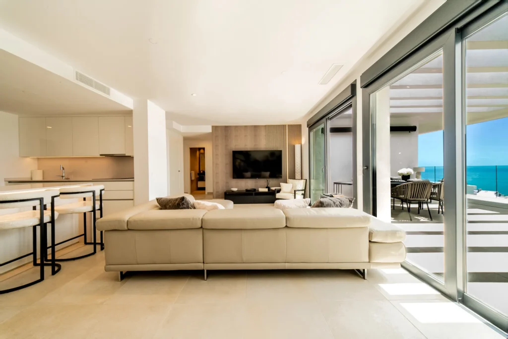 Open-plan living room and kitchen opening onto a sea-view terrace